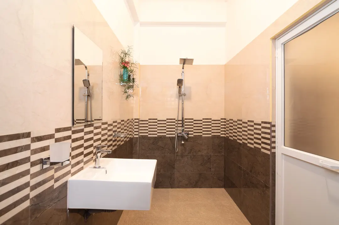 A bathroom in sand and brown tiles with a walk-in shower