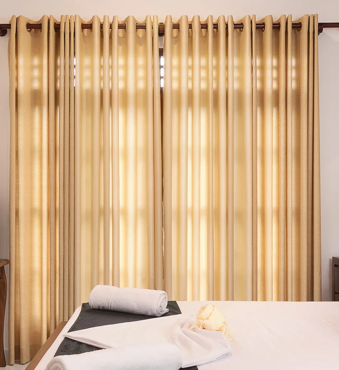 Late sun through gold curtains onto the bed
