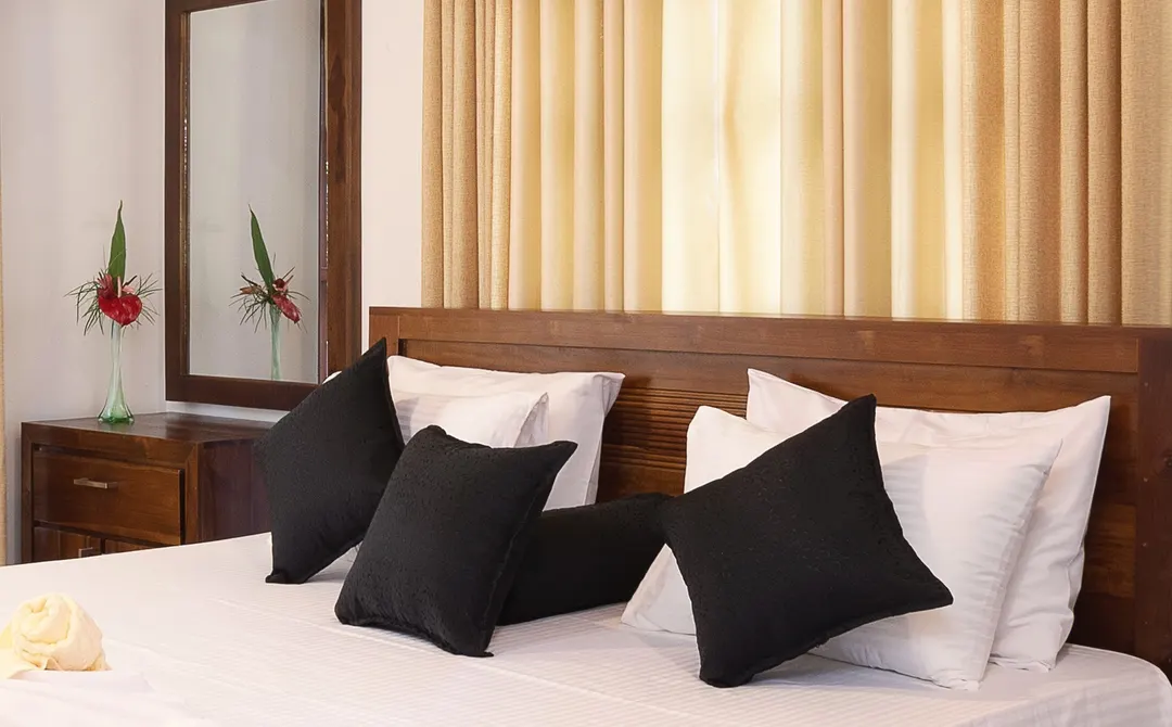 A timber headboard with white and charcoal cushions