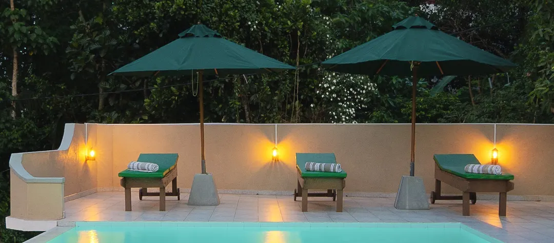 Loungers under umbrellas, with lamps along the far wall