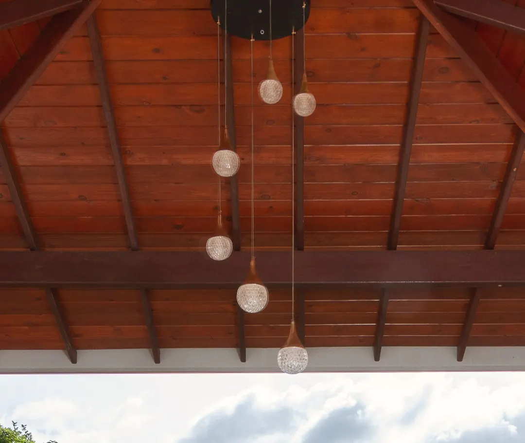 The timber ceiling and glass pendant lamps of the top-floor terrace
