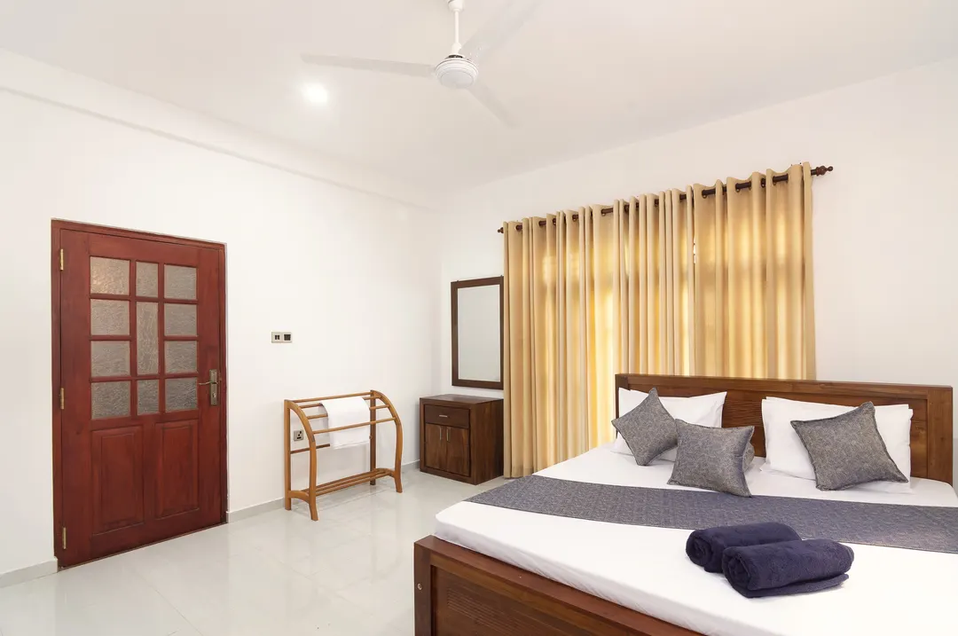 A Deluxe Double with a flat ceiling, a timber door and a towel rail