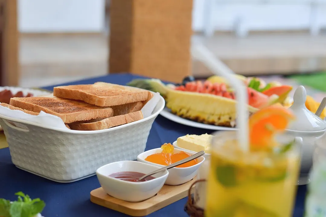 Toast, preserves, a fruit platter and fresh juice on the breakfast table