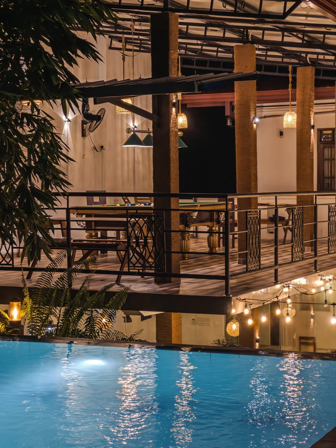 The restaurant lit up beneath the pool table terrace, the pool in front