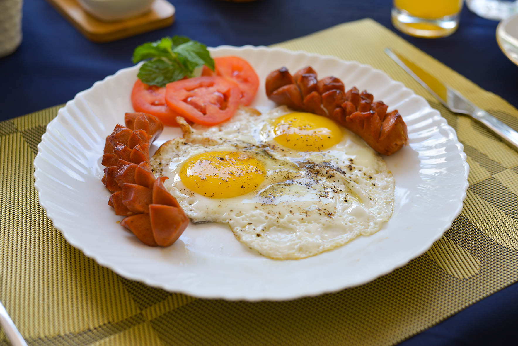 Savory breakfast at Tranquil Escape villa in Hikkaduwa, Sri Lanka. Enjoy sunny-side-up eggs, grilled sausages, and fresh tomato slices for a delicious start to your day