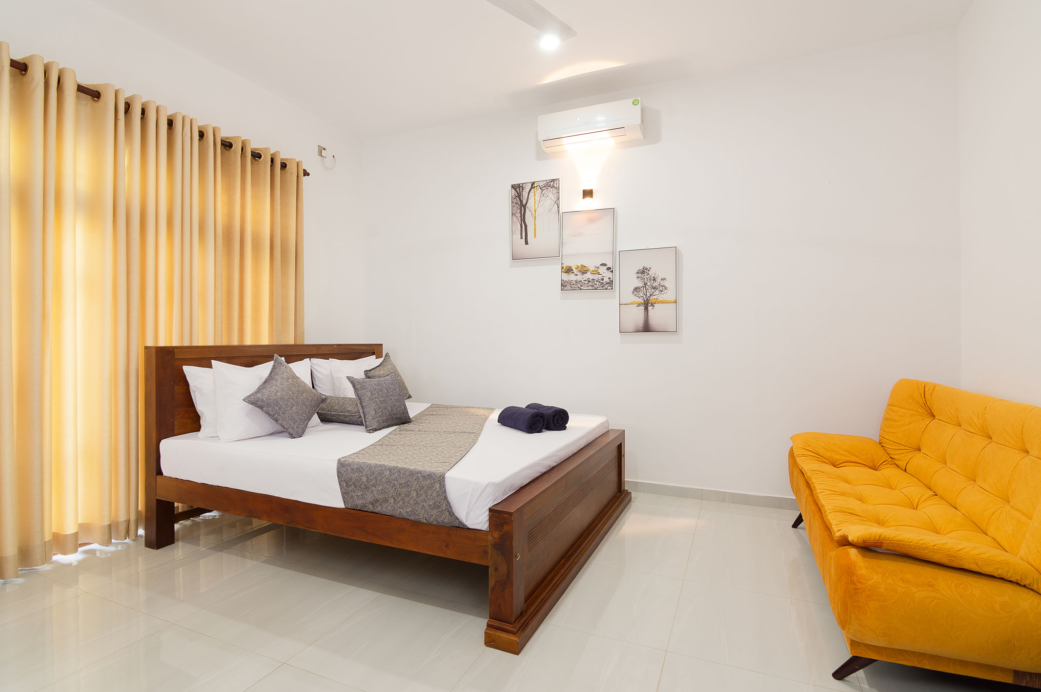 Modern and spacious guest room at Tranquil Escape villa in Hikkaduwa, Sri Lanka. Featuring a comfortable king-size bed, air conditioning, a sofa, and stylish decor. Ideal for couples or families seeking a luxurious getaway.