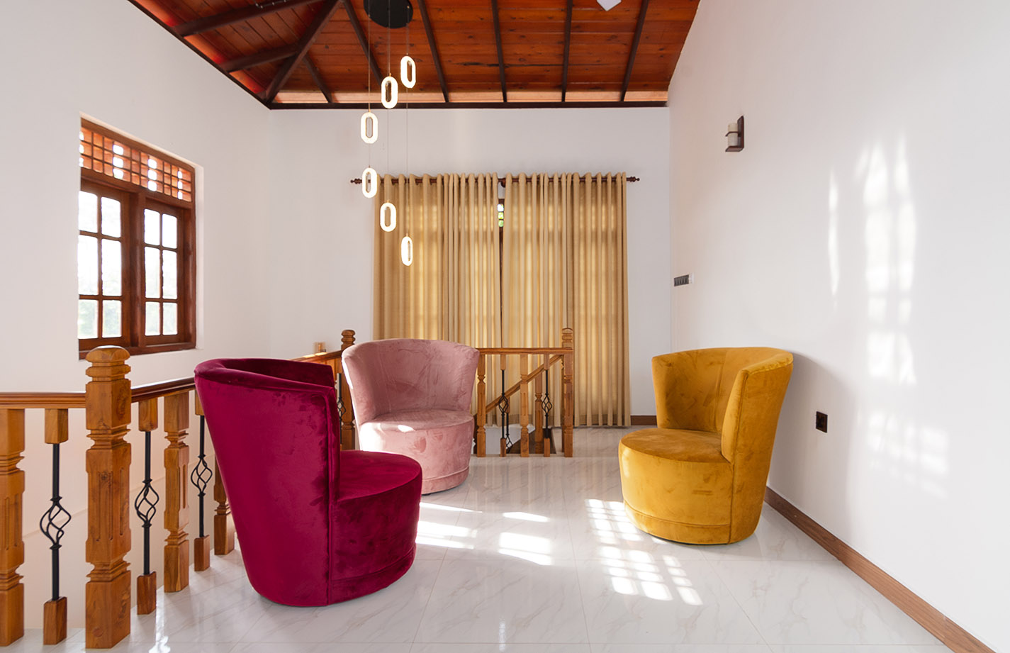 Tranquil Escape Hikkaduwa: Luxurious upper floor lounge with vibrant velvet armchairs, wooden ceiling, modern pendant lights, and panoramic windows overlooking tropical landscape