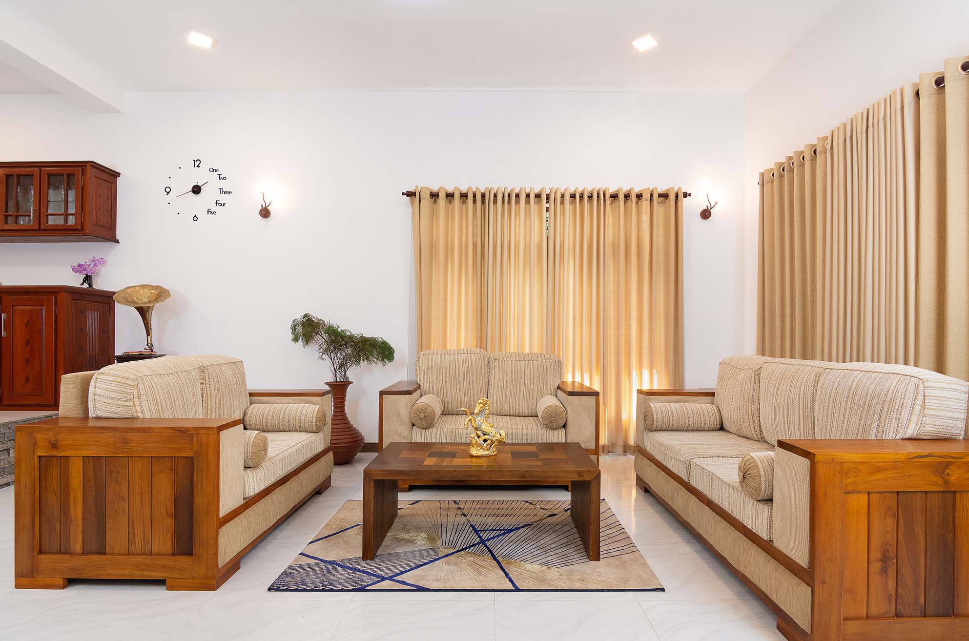 A cozy living room in Tranquil Escape villa, Hikkaduwa, featuring wooden furniture and a classic clock.