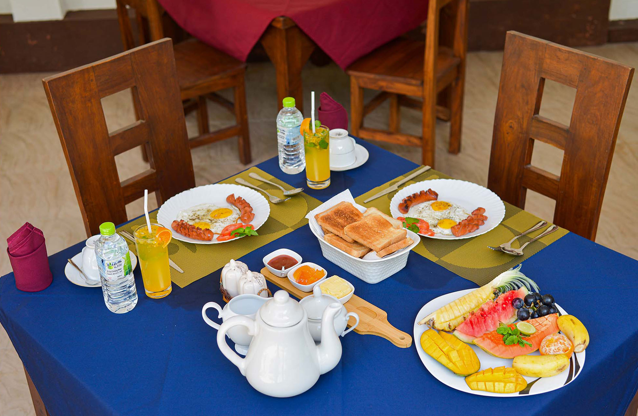 Delicious breakfast spread at a luxury villa in Hikkaduwa, Sri Lanka. Enjoy a variety of fresh fruits, eggs, and beverages served in a beautifully set dining area.