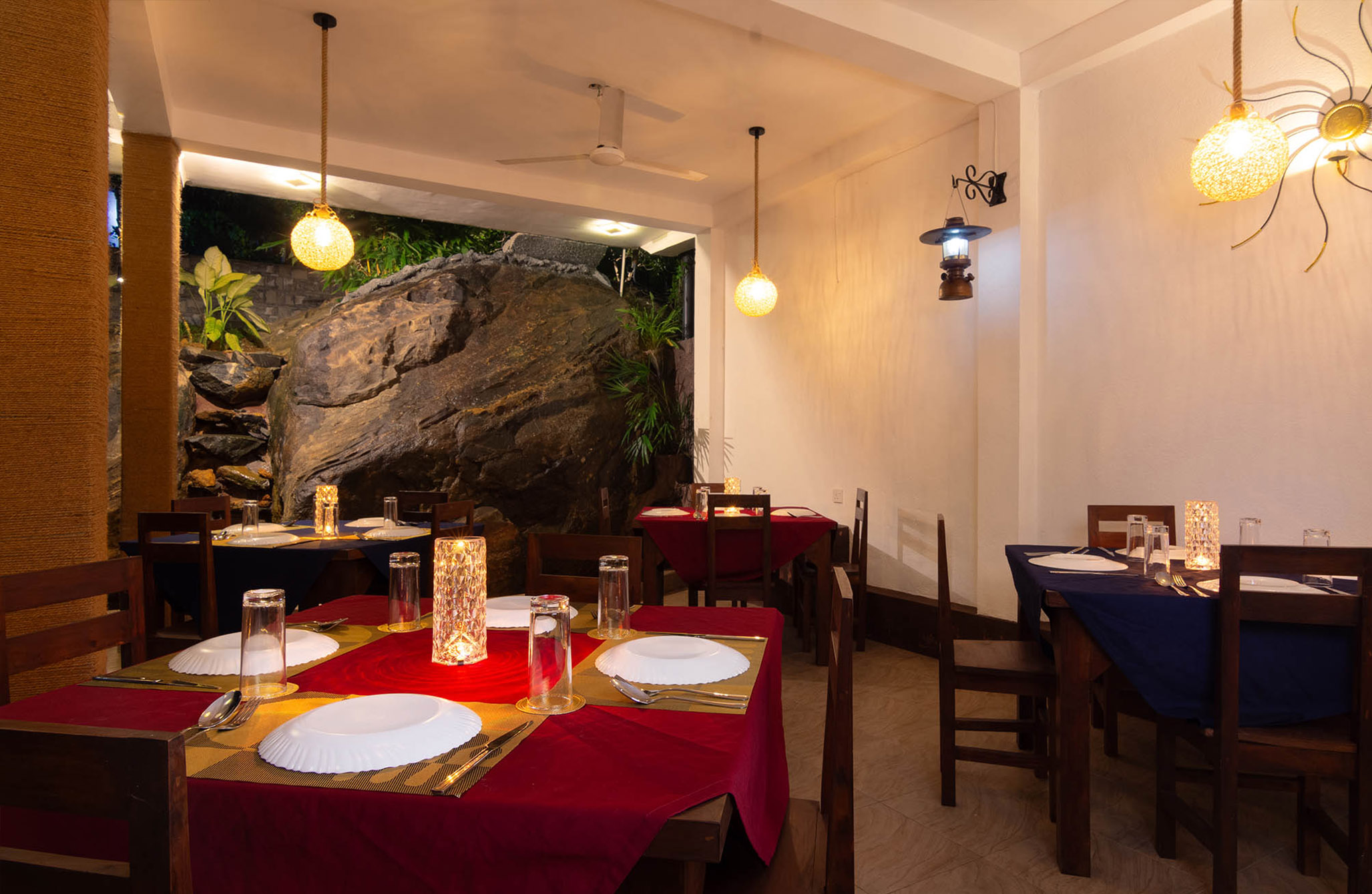 Cozy and inviting dining room at a luxury villa in Hikkaduwa, Sri Lanka. Enjoy a romantic dinner surrounded by elegant decor and a natural stone feature wall.