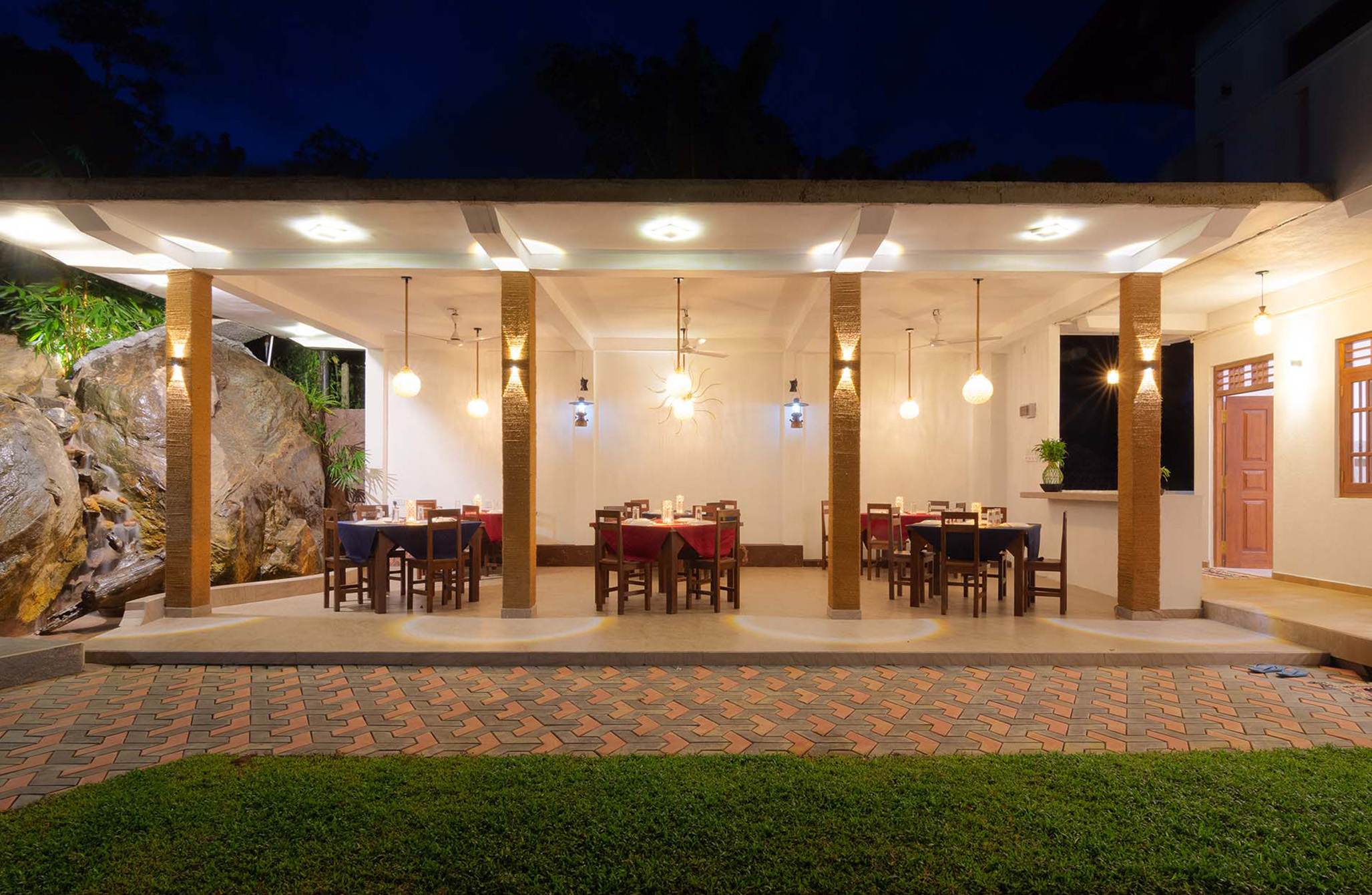 Serene outdoor dining area at a luxury villa in Hikkaduwa, Sri Lanka. Enjoy a romantic dinner under the stars surrounded by lush greenery and ambient lighting.